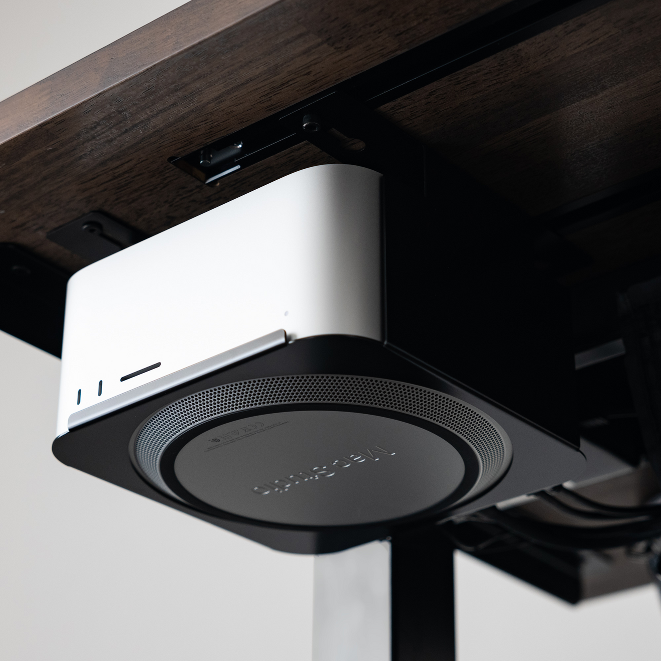 Mount for Mac Studio in Black, mounted under a desk top